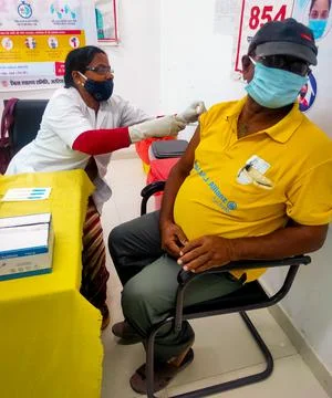 Araria-Bihar-India-03-30-2021- Woman doctor or nurse giving syringe vaccine, Stock Photos