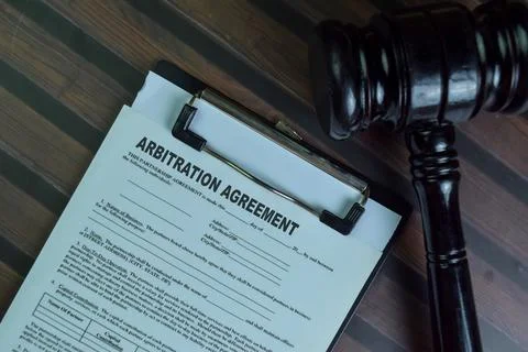 Arbitration Agreement write on a paperwork isolated on Wooden Table. Stock Photos