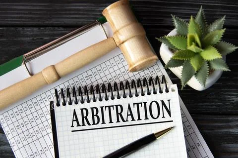 ARBITRATION - word on a white sheet on the background of a judge's gavel, a c Stock Photos