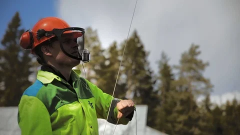 Arborist prepares to stretch the rope Stock Footage 97359445