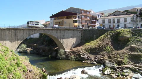 Arc bridge in town over river with spillway Stock Footage 49056859