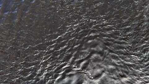 Arc of bubbles cutting through dark rippling floodwaters Stock Footage 315548233