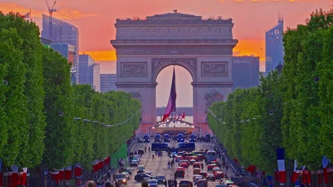 Arc de Triomphe against the backdrop of a beautiful sunset. French flag in the Stock Footage 313989070