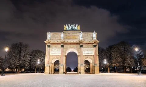 Arc de Triomphe du Carrousel illuminated at night with snow in Paris Stock Photos