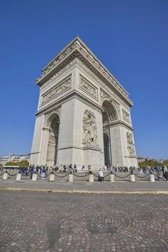 Arc de Triomphe monument in Paris with tourists under clear blue sky Stock-Fotos