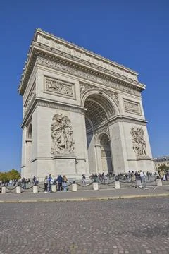 Arc de Triomphe monument in Paris with tourists under clear blue sky Stock-Fotos