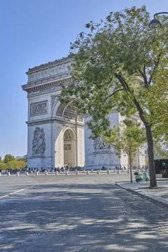Arc de Triomphe monument in Paris with tourists under clear blue sky Stock-Fotos