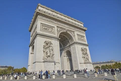 Arc de Triomphe monument in Paris with tourists under clear blue sky Stock-Fotos