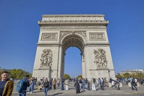 Arc de Triomphe monument in Paris with tourists under clear blue sky Stock-Fotos
