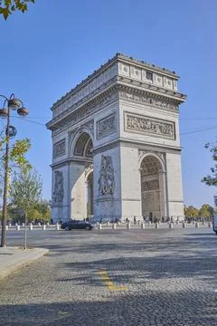 Arc de Triomphe monument in Paris with tourists under clear blue sky Stock-Fotos