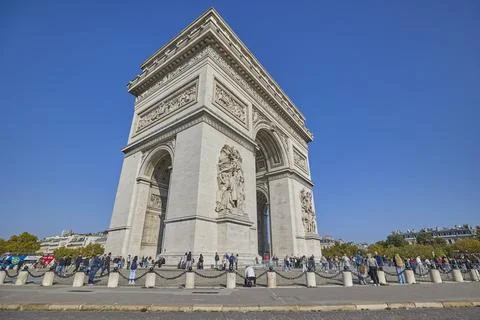 Arc de Triomphe monument in Paris with tourists under clear blue sky Stock-Fotos