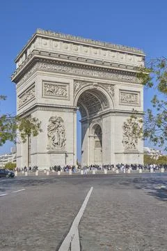Arc de Triomphe monument in Paris with tourists under clear blue sky Stock-Fotos