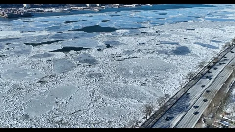 Arc Left Aerial Over Hudson Ice Pans Toward Parkway Traffic In Manhattan Vídeo Stock 342647764