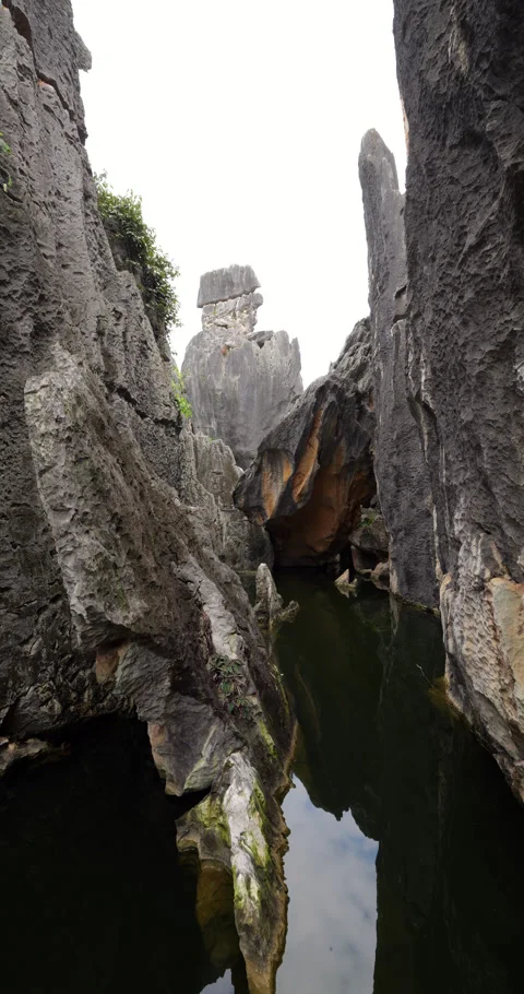Arc shot of sharp stone sticking out water, scenic rocks on background Stock-Footage 329596992