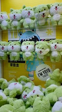 Arcade claw machine packed with green soft toys Stock Photos