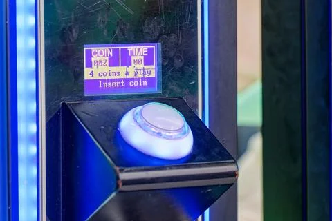 Arcade game machine illuminated button with coin insert display and blue li.. Stock Photos