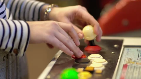 Arcade gamer holding a white bubble top joystick and playing on a four button Stock Footage 146615682