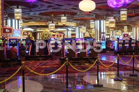 Arcade machines and gamblers inside casino in Macau Stock Photos