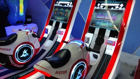 Arcade Motorcycle Racing Simulation Machines with Bright Lights and Screens Stock Footage 309840860
