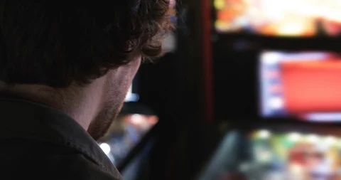 Arcade: Rear View Of Man Playing Pinball Stock Footage 107944483