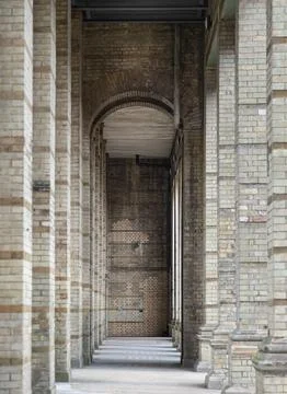 The arcade stretched out like a rhythmic countdown of stone and shadow. Eac.. Stockfoto's