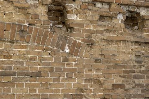 Arch in ancient brickwork on abandoned old house red brick wall fragment Stock Photos