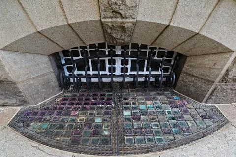 Arch basement window-decorative grillwork-colored pavement lights. Brisbane-AUS Stock Photos