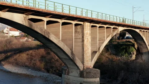 Arch bridge over the river - concrete  structure used in transportation spanning Stock Footage 232383207