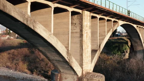 Arch bridge over the river - concrete  structure used in transportation spanning Stock Footage 232390690