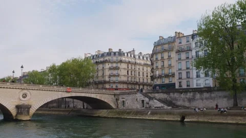 The arch bridge Pont Louis-Philippe and people relaxing on the embankment, Paris Stock Footage 308729363