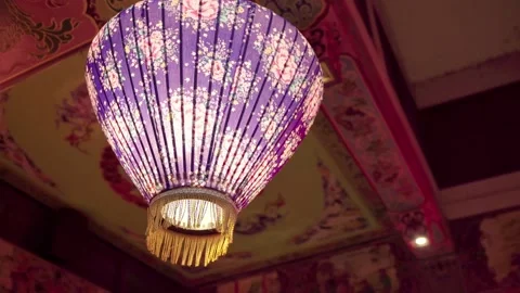 A arch camera move take of a purple  lantern with flower patterns on hung on. Stock Footage 140253667