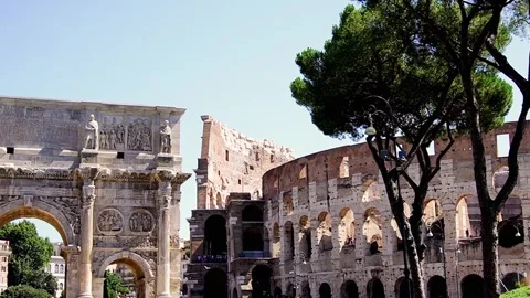 The Arch of Constantine and the Colosseum with stone pine trees in Rome, Italy Stock Footage 332642798