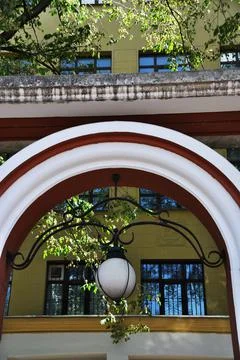Arch element with a lantern. White arch with a white, round lantern. Stock Photos