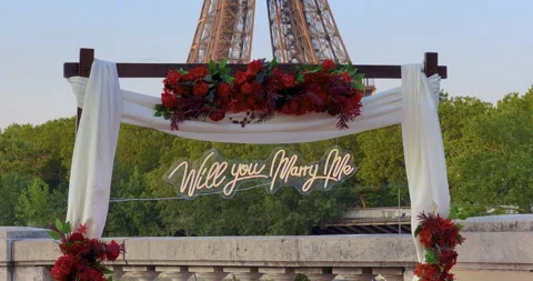 Arch with flowers in front of the Eiffel Tower in Paris. Establishing shot man Stock Footage 244984135