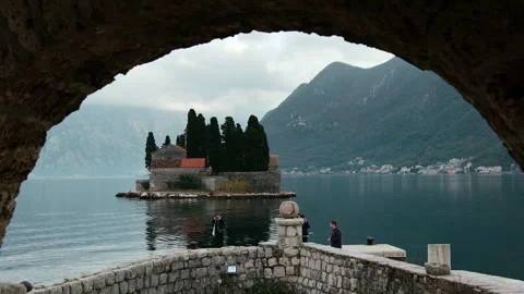 Arch framed view of Saint George Catholic Monastery, Perast, Montenegro Stock Footage 337301548
