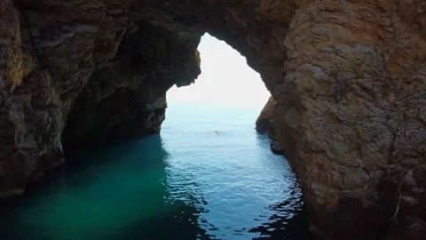 Arch in rock formations around a blue water sea Stock Footage 234857309