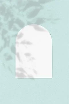 An arch-shaped sheet of white textured paper on a blue wall background. Overlay Stock Illustration