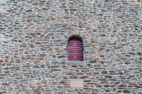 Arch window set in an old stone wall Stock Photos