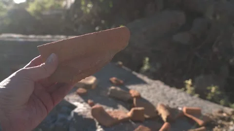 Archaeologist Hand holding ancient broken ceramic brick Stock Footage 330604719