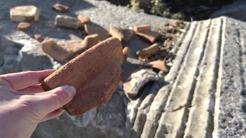 Archaeologist Hand holding ancient broken ceramic brick Stock Footage 330604753