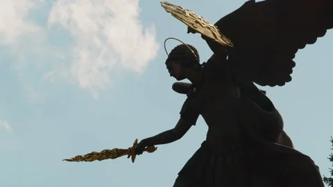 Archangel statue at a midday sky background, static view with moving clouds Stock Footage 228381615