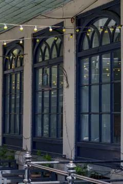 Arched blue windows with string lights above outdoor terrace Stock Photos