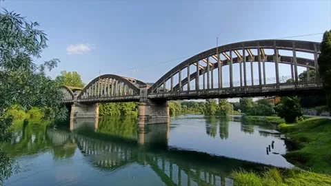 Arched bridge crosses the river Stock Footage 131973520
