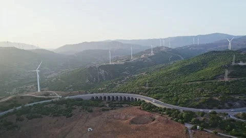 Arched bridge in the mountains and windmills sunset Stock Footage 232715305