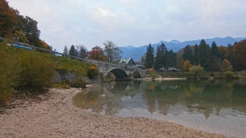 An arched bridge over a pond with reflection of a bridge in a ripple of water. Stock Footage 119680046