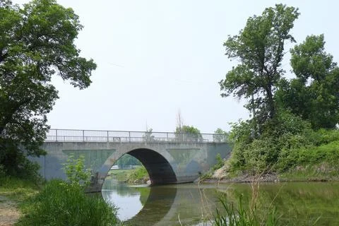 Arched bridge over the river Stock Photos