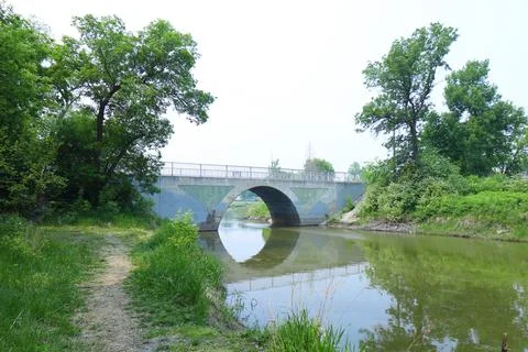 Arched bridge over the river Stock Photos