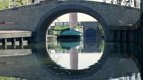 Arched bridge reflecting creating a perfect circle on a canal 스톡 동영상 335834908