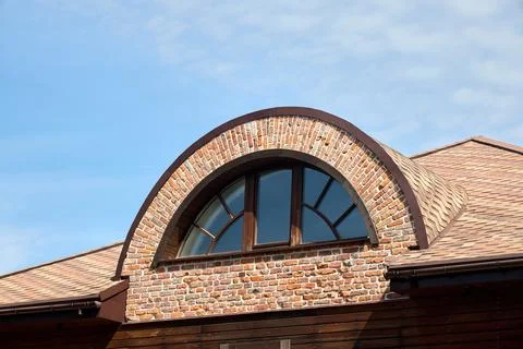 An arched dormer window featuring a semi-circular brick surround, multi-pan.. Stock Photos