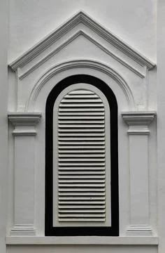Arched Louvered Window on White Classical Building Facade Stock Photos